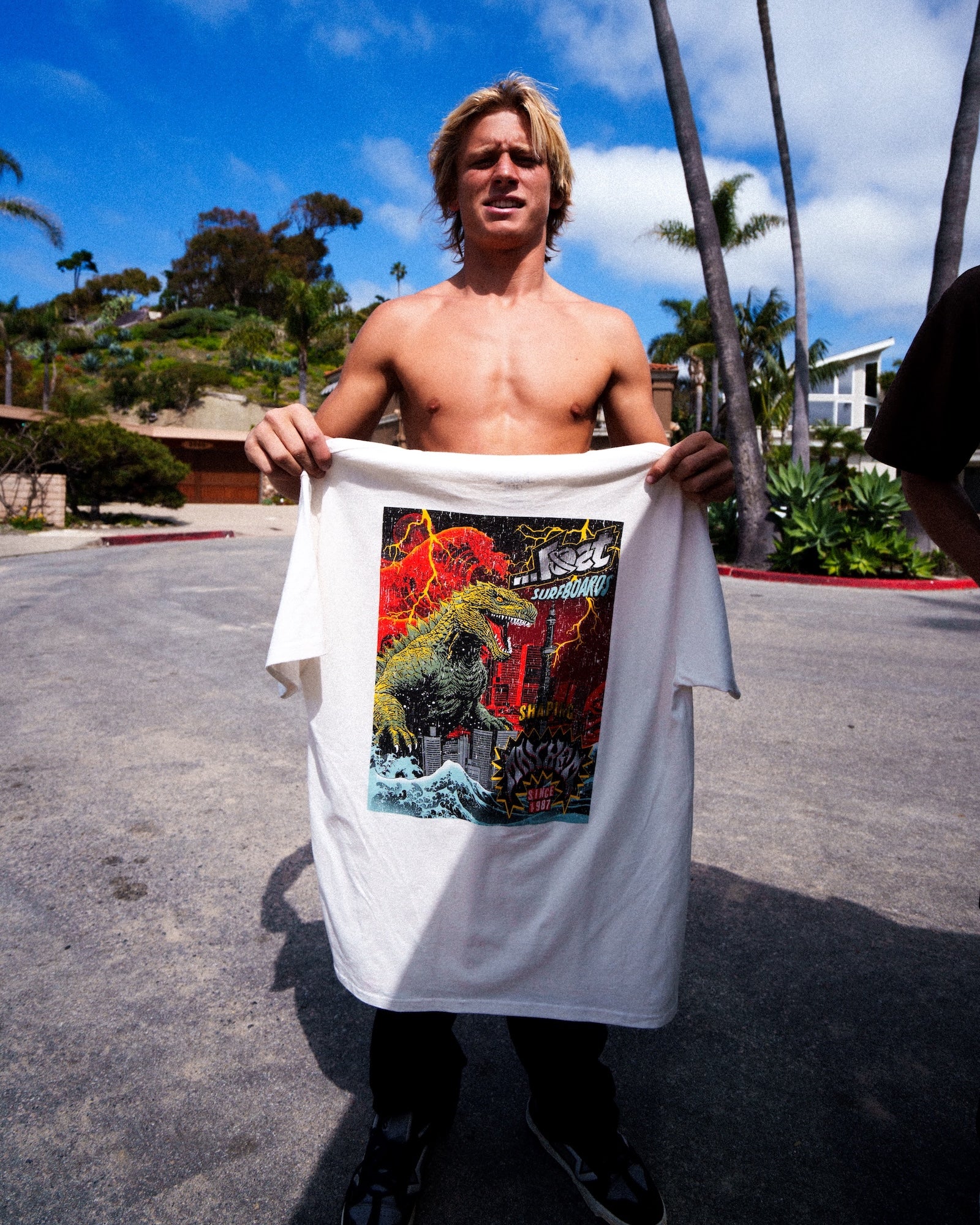 Shirtless man displaying colorful t-shirt