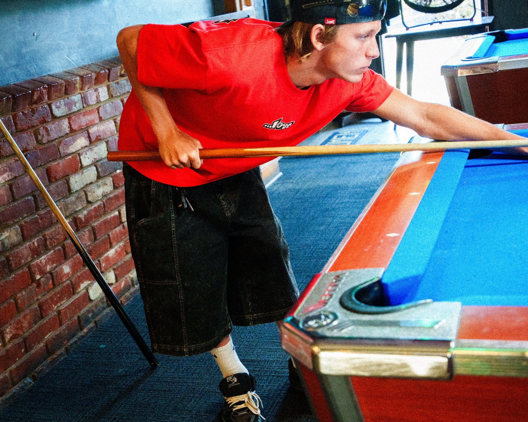 Young man aiming pool cue.