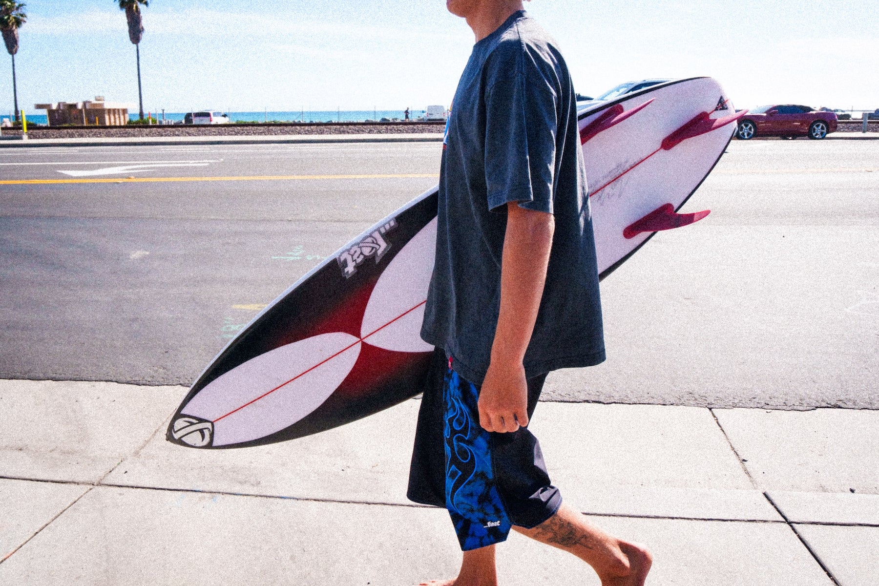 Surfer carrying board near oceanfront street