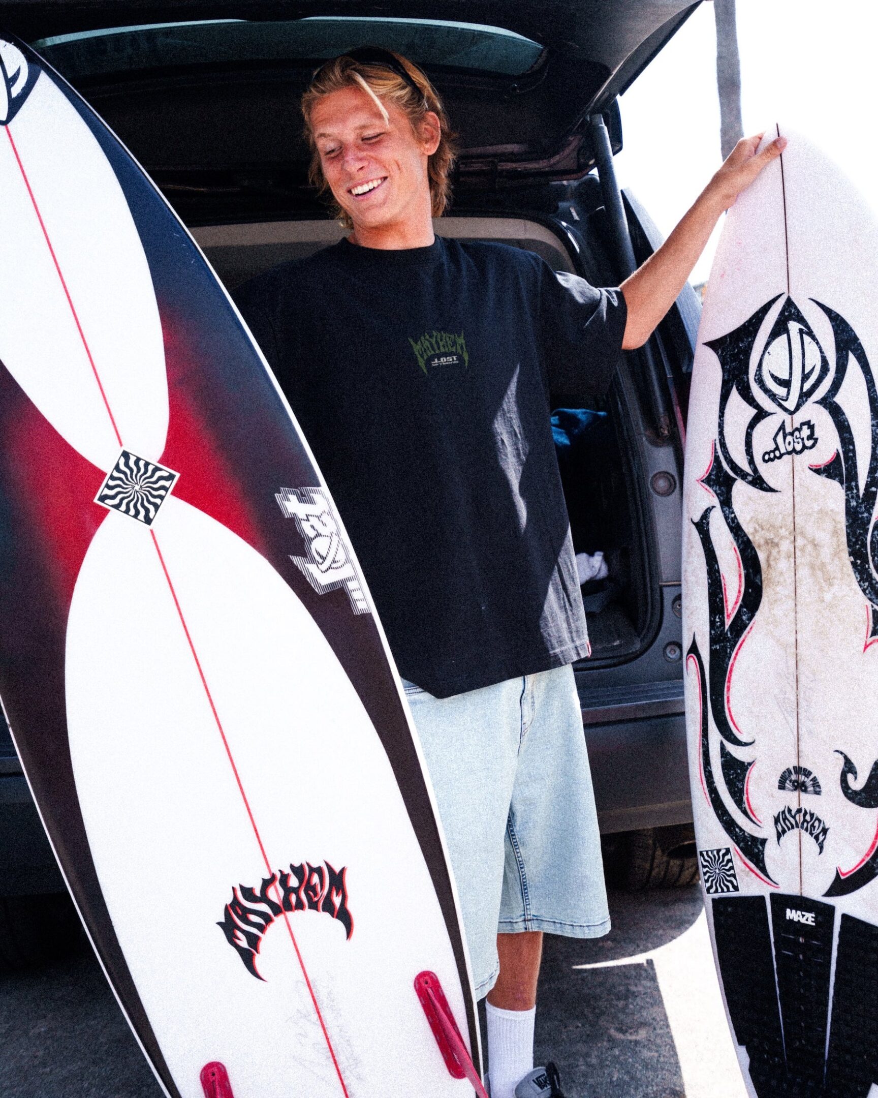 Smiling man with surfboards in hand
