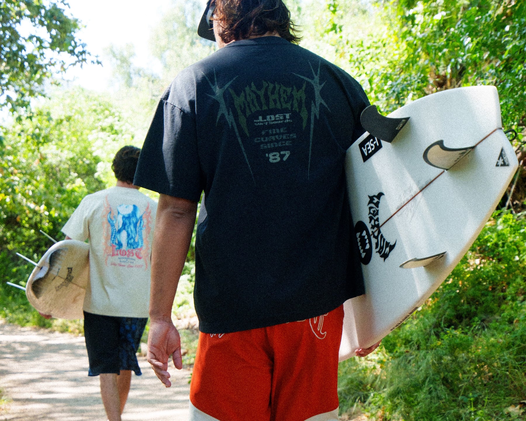 Back view of surfers heading to the beach.