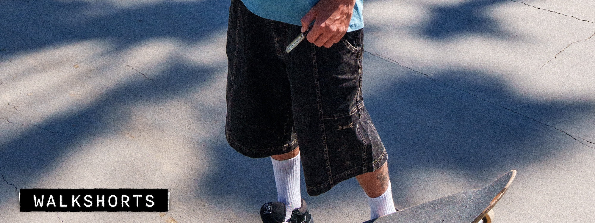 Man with skateboard and shorts