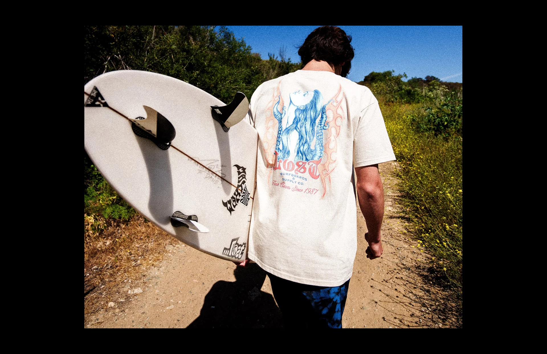 Person walking with surfboard outdoors