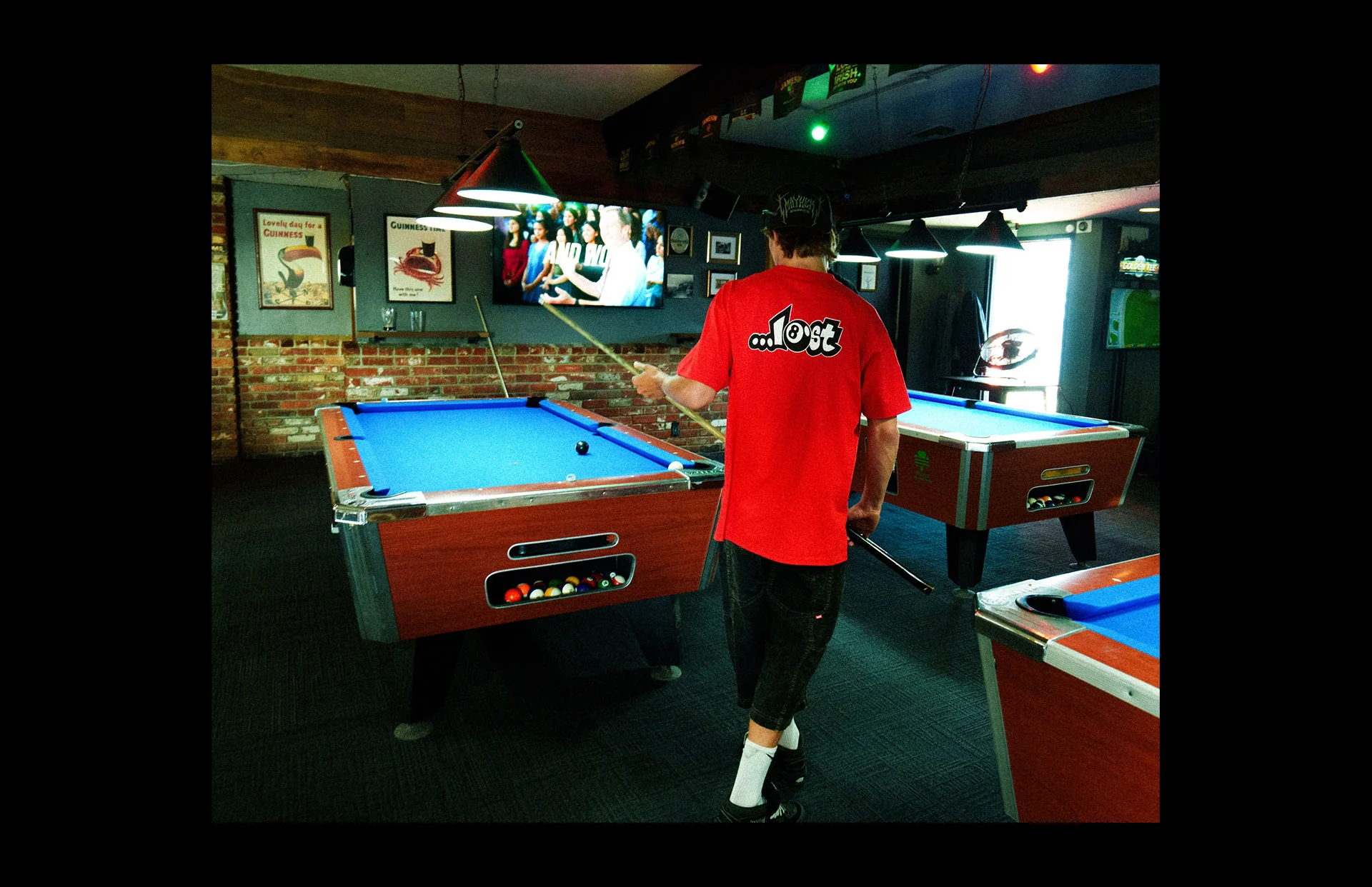 Pool player in red shirt aiming shot